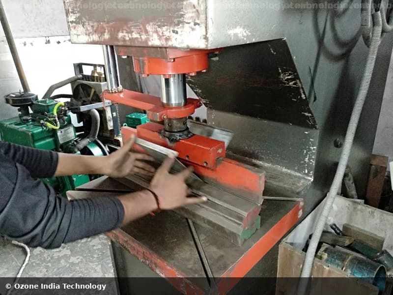 Worker operating a hydraulic punch press for sheet metal forming